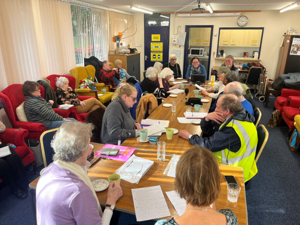 Centre users and volunteer scribes seated in pairs around a table