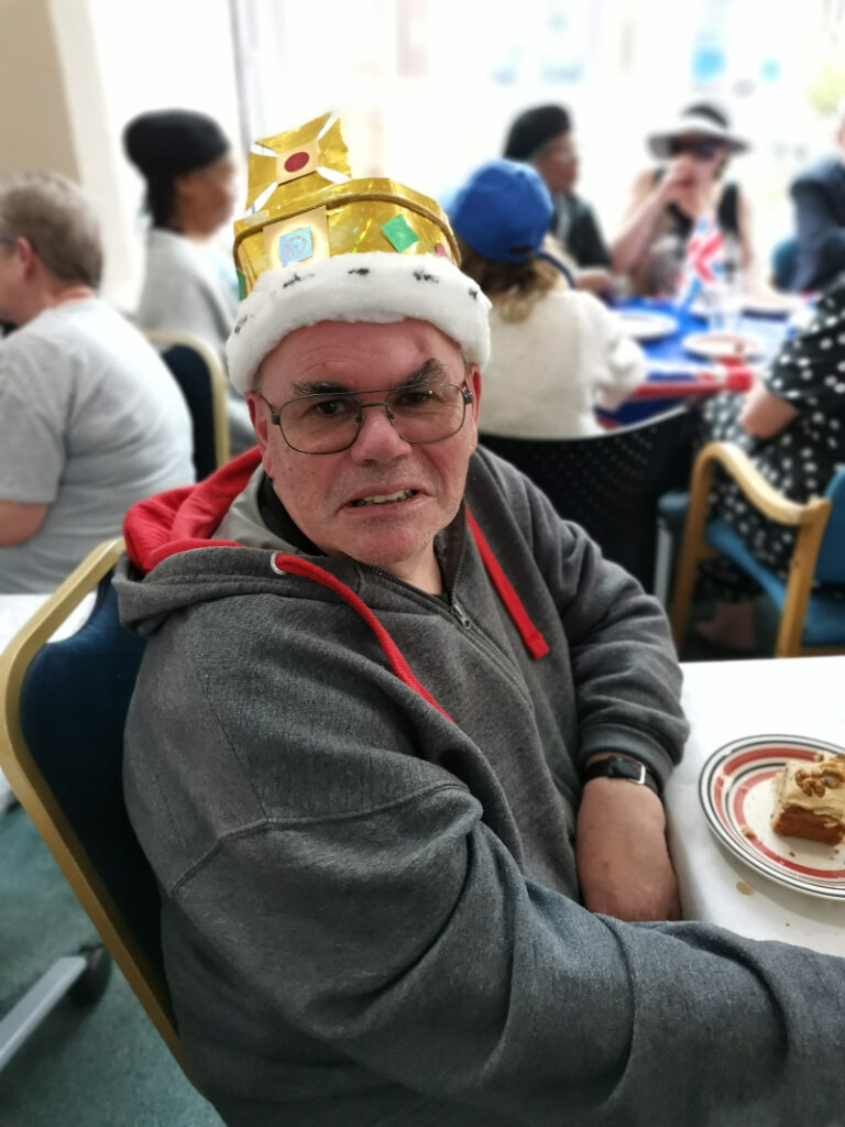 James at the Coronation tea party wearing a gold cardboard crown