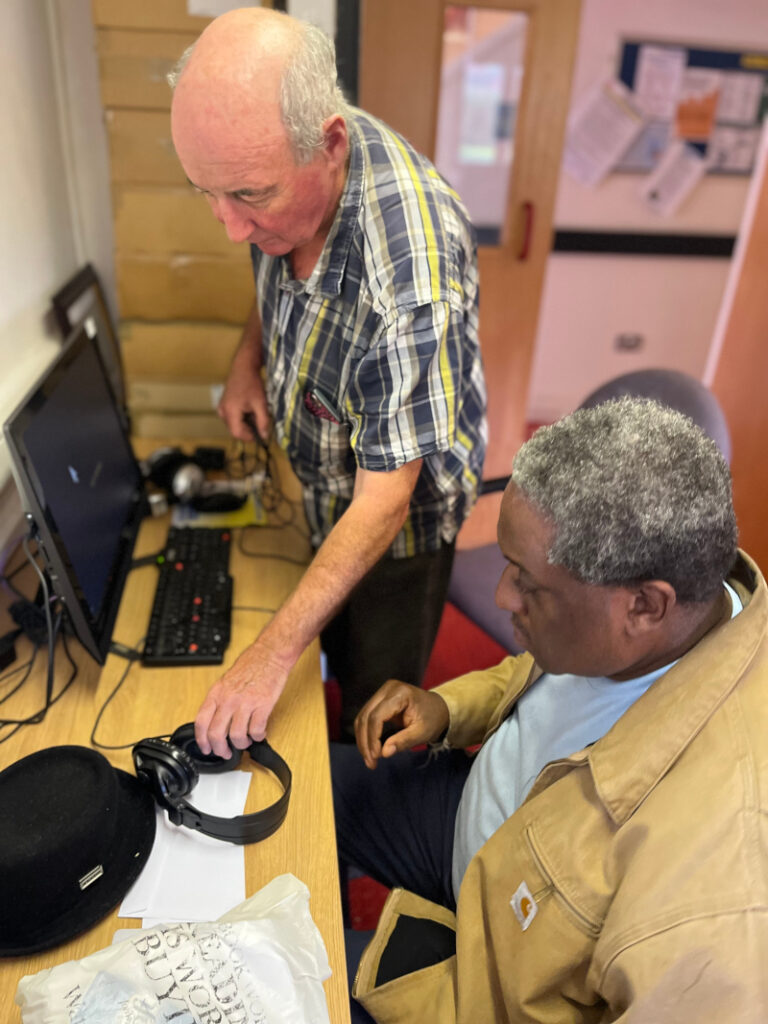 A volunteer supporting a centre user in an IT session