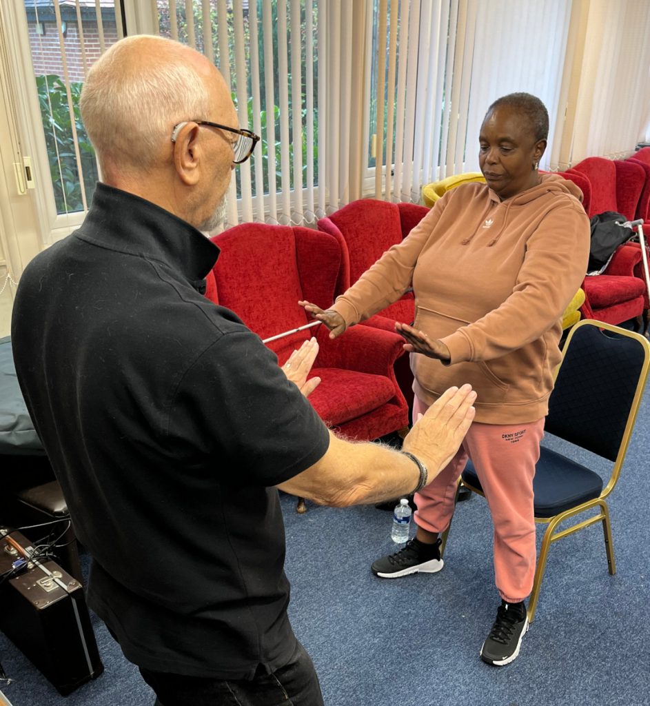 T'ai Chi instructor showing a form to a visually impaired student